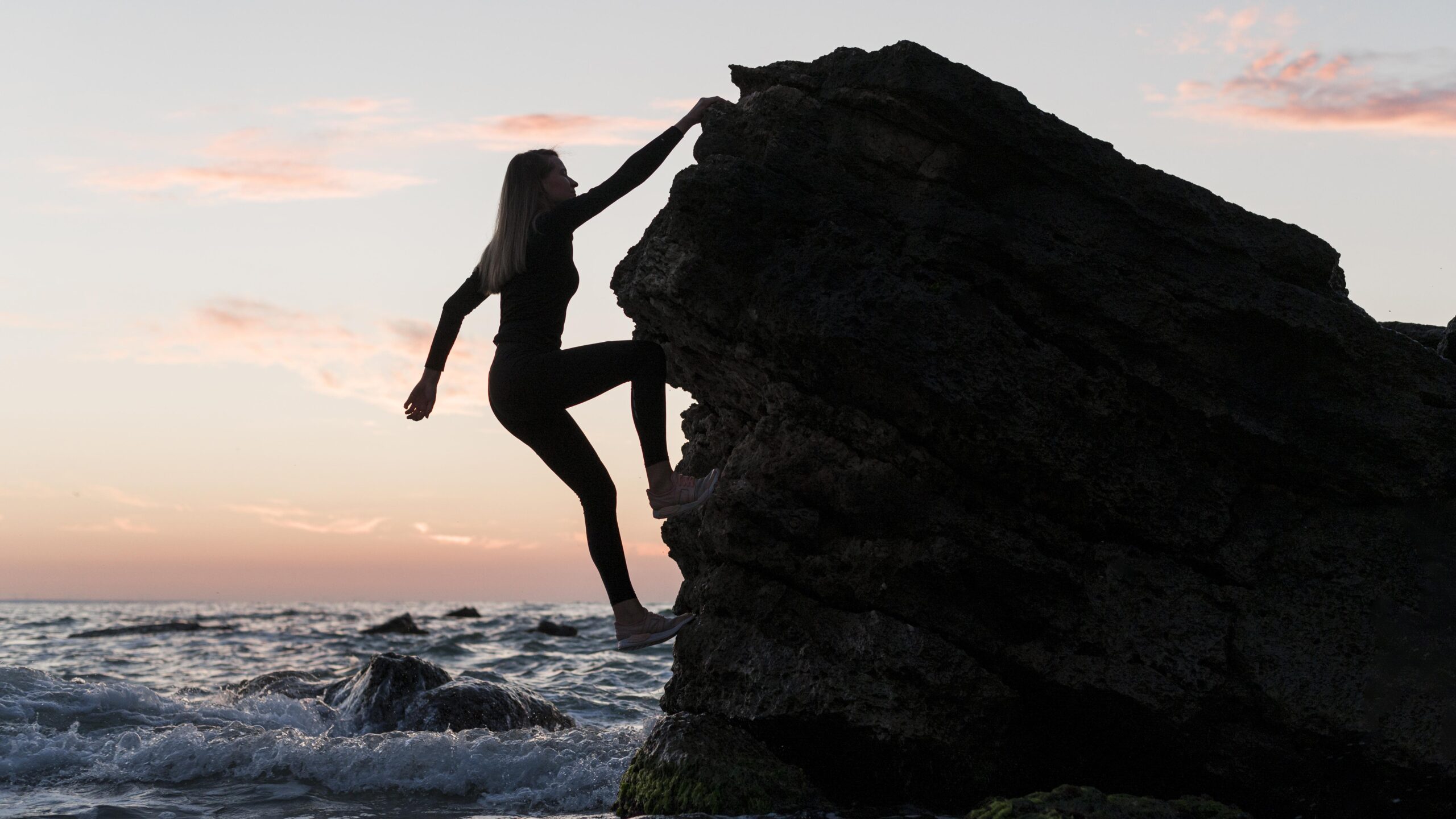 a person embracing growth mindset theory by climbing a big mountain of obstacles