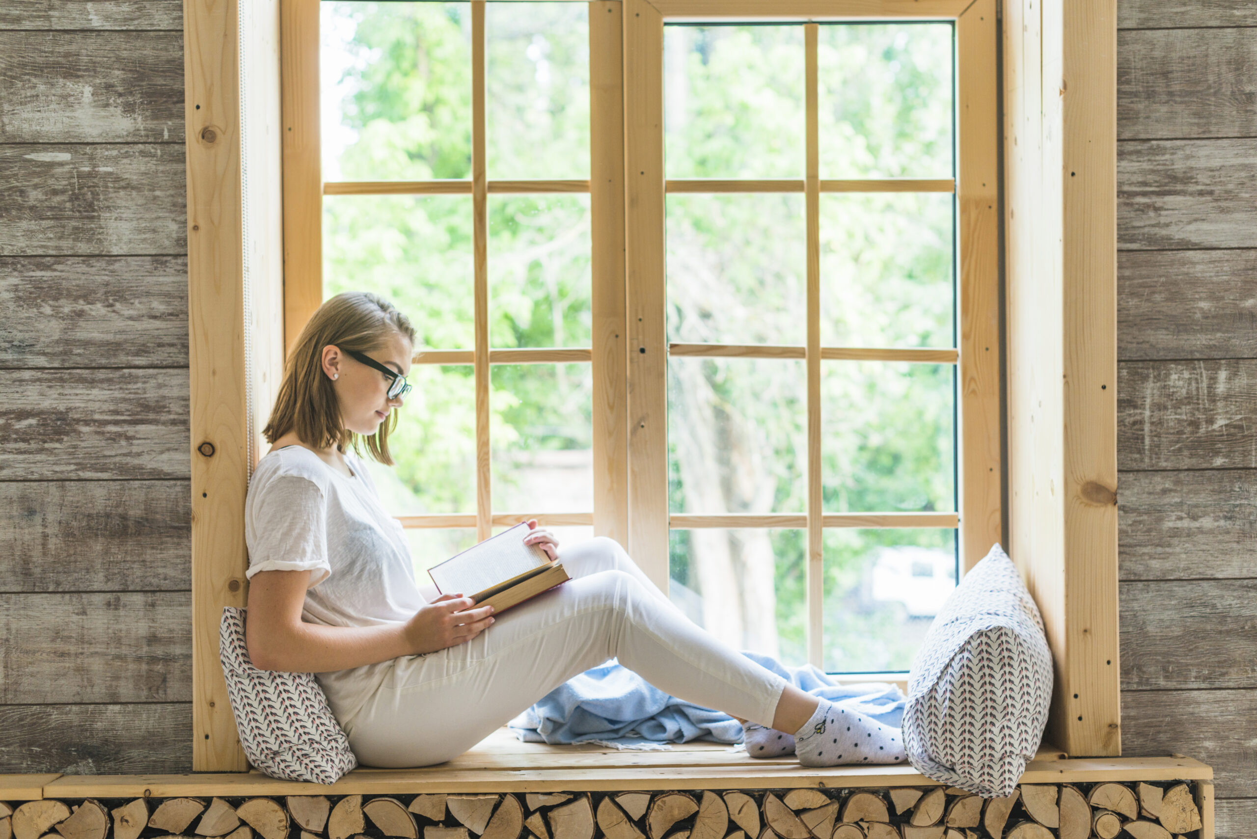 how to work on yourself - a woman sitting on a window and reading