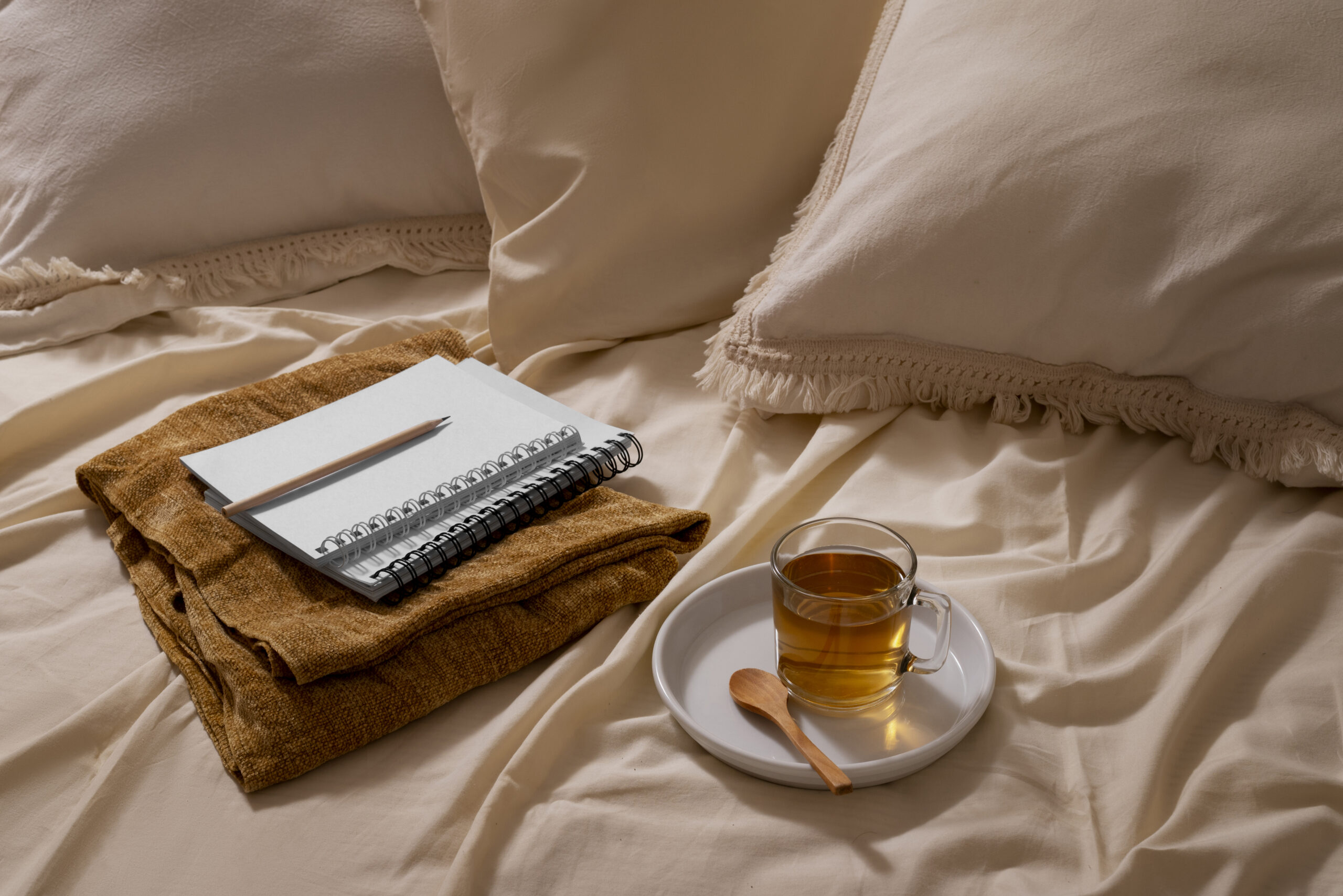 Beginners journal on a cozy bed with tea, ready to start journalling