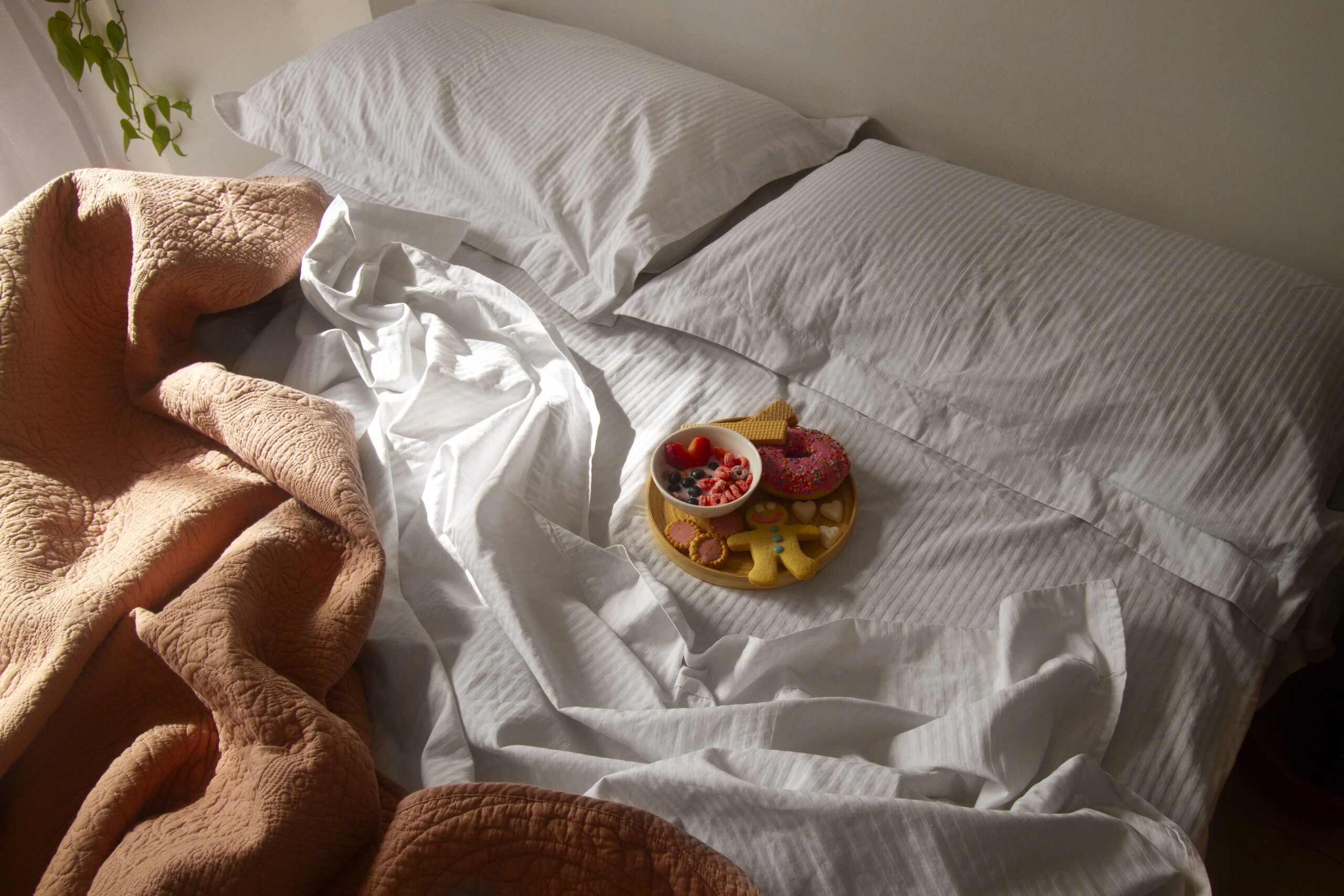 A serene, softly lit bedroom at sunrise, warm golden light streaming through sheer curtains, a bedside table with a sleek wake-up light alarm clock glowing gently, a glass of water, and a journal with a pen. Calm, minimal, and inviting atmosphere representing calm morning rituals