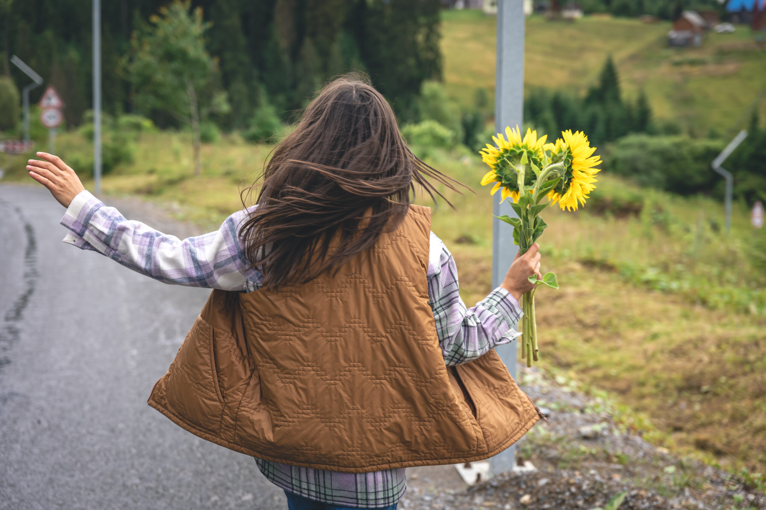 end of summer reset with a Woman with a bouquet of sunflowers in nature in a mountainous area